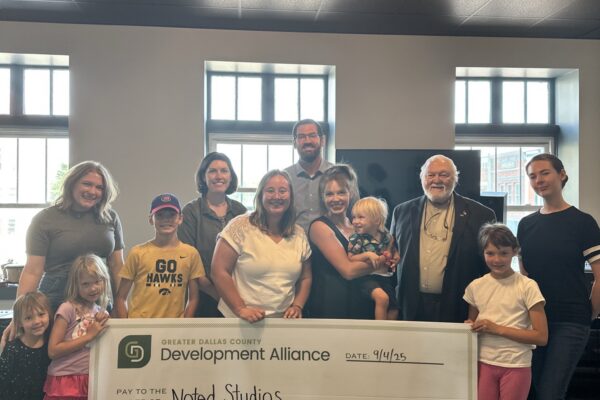 Rachel Wacker and Grace Grob from the Greater Dallas County Development Alliance present a check for $3,000 to Noted Studios, a recipient of the Small Business Grant Fund.